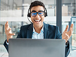 Young happy mixed race businessman looking shocked while working on a laptop alone at work. One hispanic businessperson looking surprised working at a desk in an office