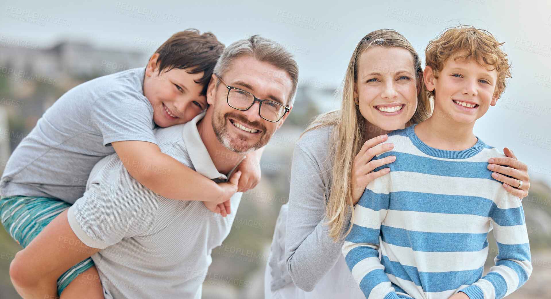 Buy stock photo Parents, children and hug at beach with portrait, smile and bonding with love on vacation in summer. Father, mother and kids on holiday for connection, embrace or together with piggy back in sunshine