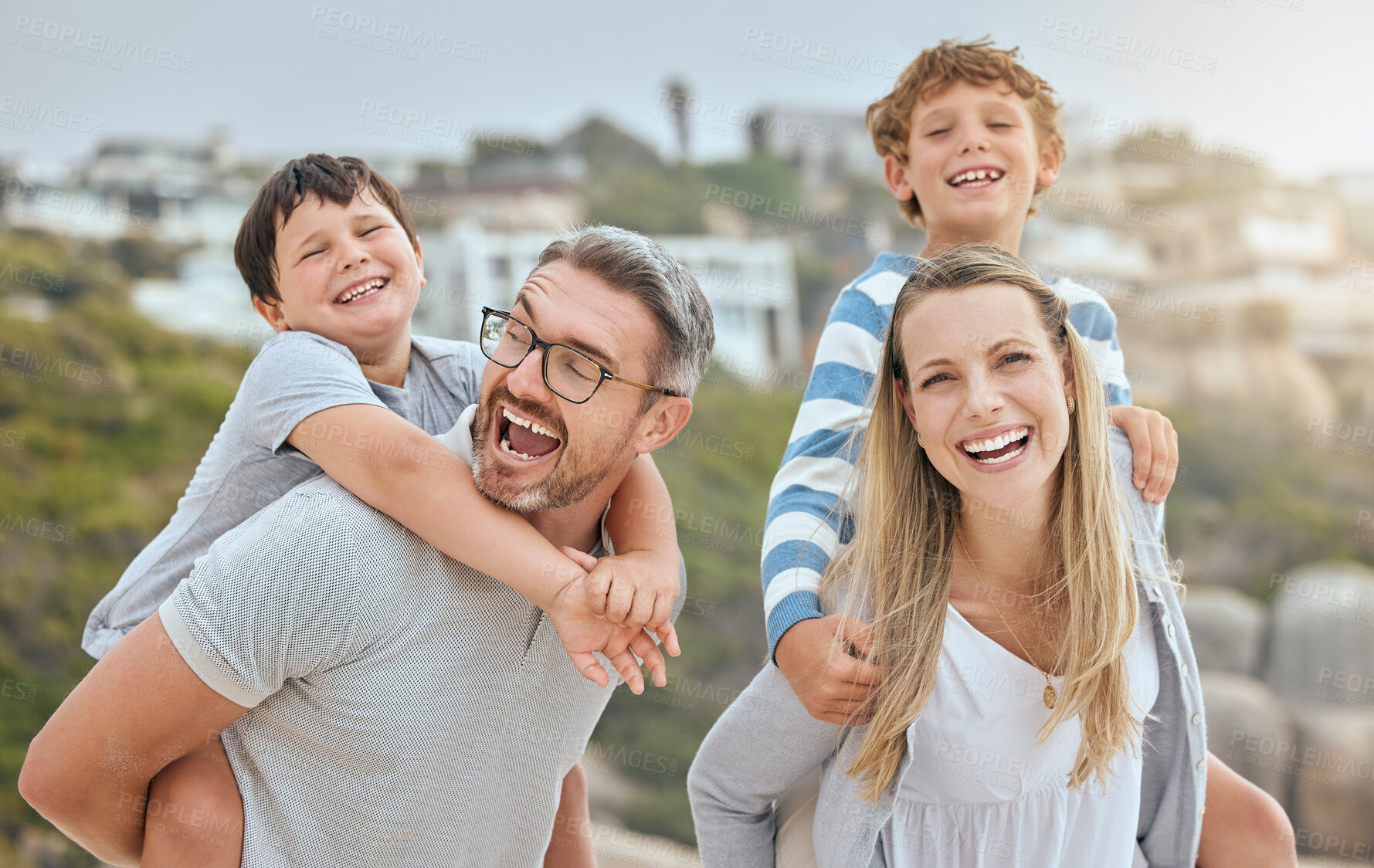 Buy stock photo Parents, children and piggy back at beach with portrait, smile or bonding with love on vacation in summer. Father, mother and kids on holiday for connection, embrace or together for laugh in sunshine