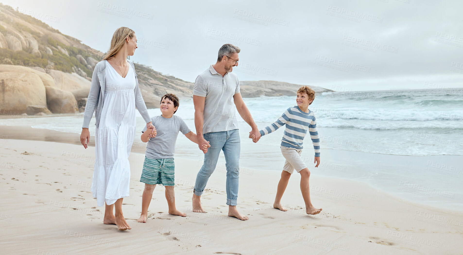 Buy stock photo Parents, children and holding hands at beach with smile, walk or bonding with love on vacation in summer. Father, mother and kids on holiday for connection, memory or talking with family in sunshine