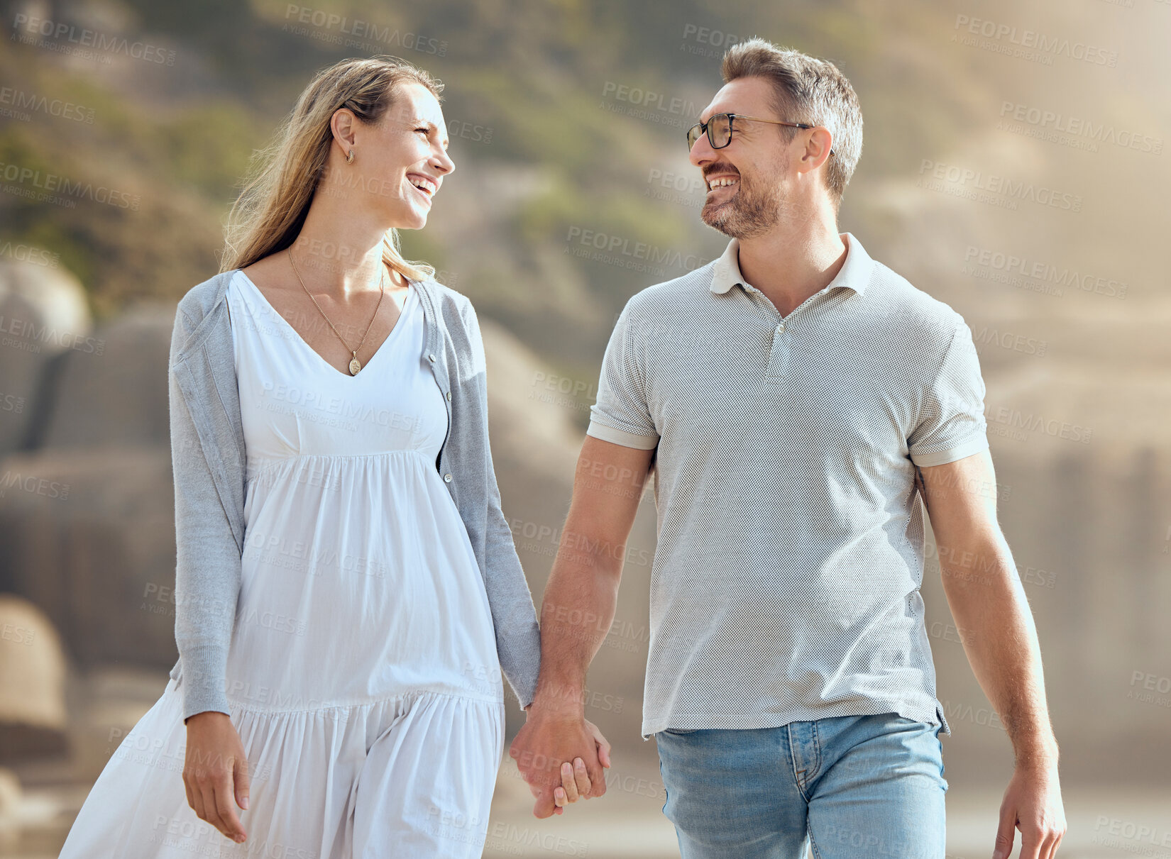 Buy stock photo Happy, couple and outdoor at beach, smile and bonding of people in vacation, man and woman in nature. Summer, walking and holding hands for love in date of anniversary, travel or together in marriage