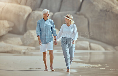 Buy stock photo Mature, couple and walking on beach with love on retirement vacation, romance and together with years of commitment. Man, woman and holding hands by ocean on holiday, happy and bonding with embrace.