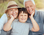 Happy caucasian grandparents sitting with grandson on a beach. Adorable, happy, child bonding with grandmother and grandfather in a garden or park outside. Boy with foster parents