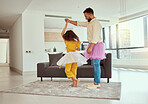 Full length mixed race single father dancing with adorable daughter in living room at home. Cute little hispanic girl wearing tutus with single parent and bonding in lounge. Man and child together