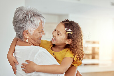 Buy stock photo Hugging, love and child with grandmother for bonding, care and connection together in home. Smile, family and girl kid embracing senior woman for support and relax in living room at house in Colombia