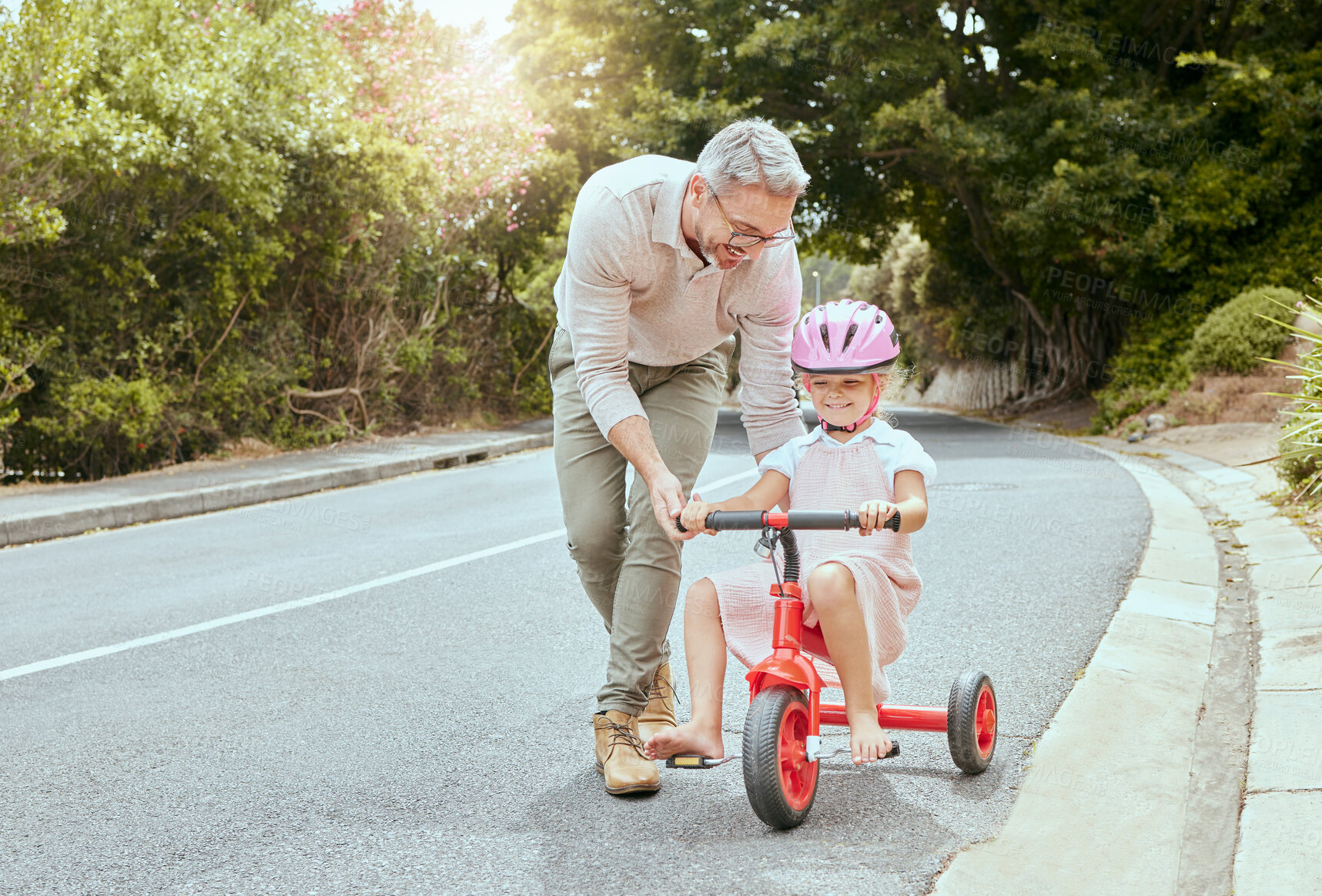 Buy stock photo Father, child and learn to ride bicycle for development, coordination exercise and trust on road. Dad, bonding and teaching young girl in nature for cycling, training wheels and support in lesson