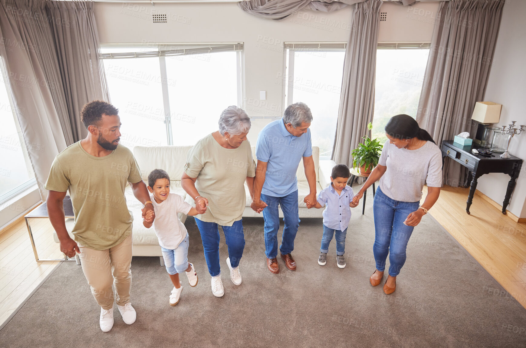 Buy stock photo Family, dance and fun in home while holding hands for bonding, support or people playing game. Grandparents, parents and children in living room for birthday party, celebration or learning with music