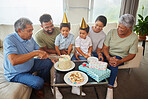 Mixed race family celebrating a birthday and having come cake at home in the loung. Hispanic relatives enjoying some sweet cake and smiling at home