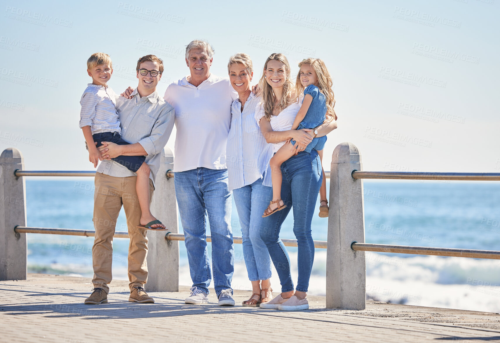 Buy stock photo Family, portrait and generations for love on beach, promenade and hug for support in outdoor. Parents, grandparents and children for embrace on vacation, bonding and holiday for seaside freedom