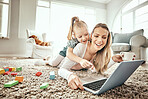 Mother, child and laptop for home games, e learning and happy video streaming or education on carpet in living room. Mom, family and girl play on floor and computer for kids website or online school 