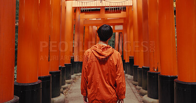 Buy stock photo Man, outdoor and walk by shinto torii gate, back and culture for thinking, ideas and nature in forest. Person, statue and memory on spiritual journey, Fushimi Inari shrine and architecture in Kyoto