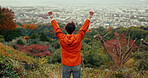 Man, fist celebration and mountain with view, city and torii gates at Fushimi Inari shrine for shinto religion. Person, hiking and cheers by trees, pillar or achievement on spiritual journey in Kyoto