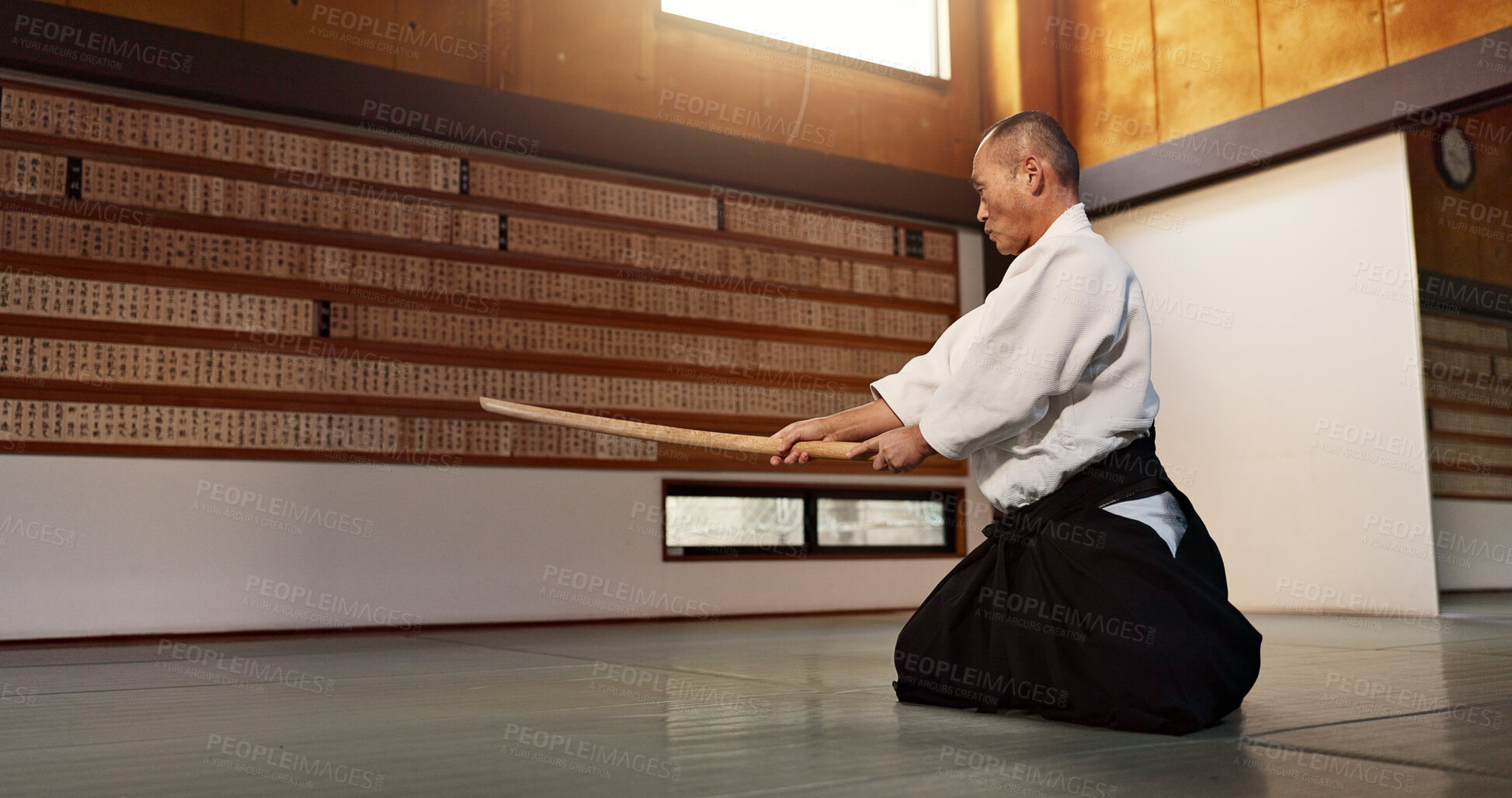 Buy stock photo Aikido with sensei, wooden sword and training for fitness, fight or action in traditional gym in Japan. Exercise, practice and mature man at dojo with black belt in professional Japanese martial arts
