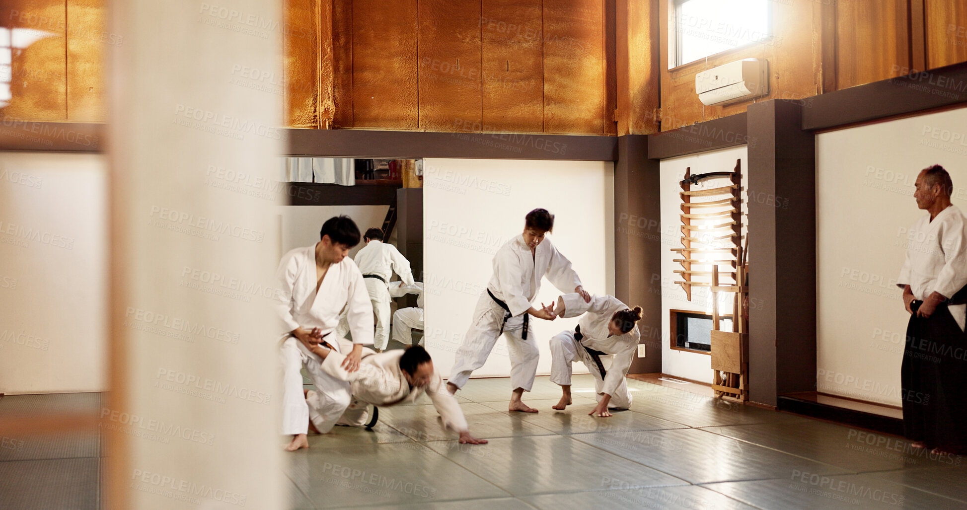 Buy stock photo Aikido dojo, students and fight for martial arts, strike or together for combat at training, gym or class. Japanese people, group and sport for exercise, workout or fitness with zen, conflict or club