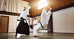 Aikido dojo with sensei, wooden sword and student training for fitness, fight and action in gym. Teaching, learning and men in traditional Japanese martial arts class with aikidoka, bokken and battle