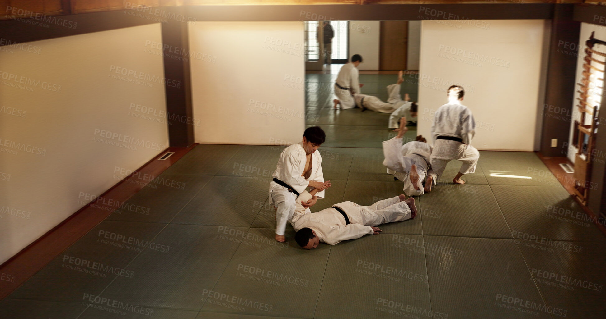 Buy stock photo Japanese men, training and aikido fighting, modern martial arts and learning self defence. Respect, black belt students and instruction in dojo place and combat demonstration for discipline in class