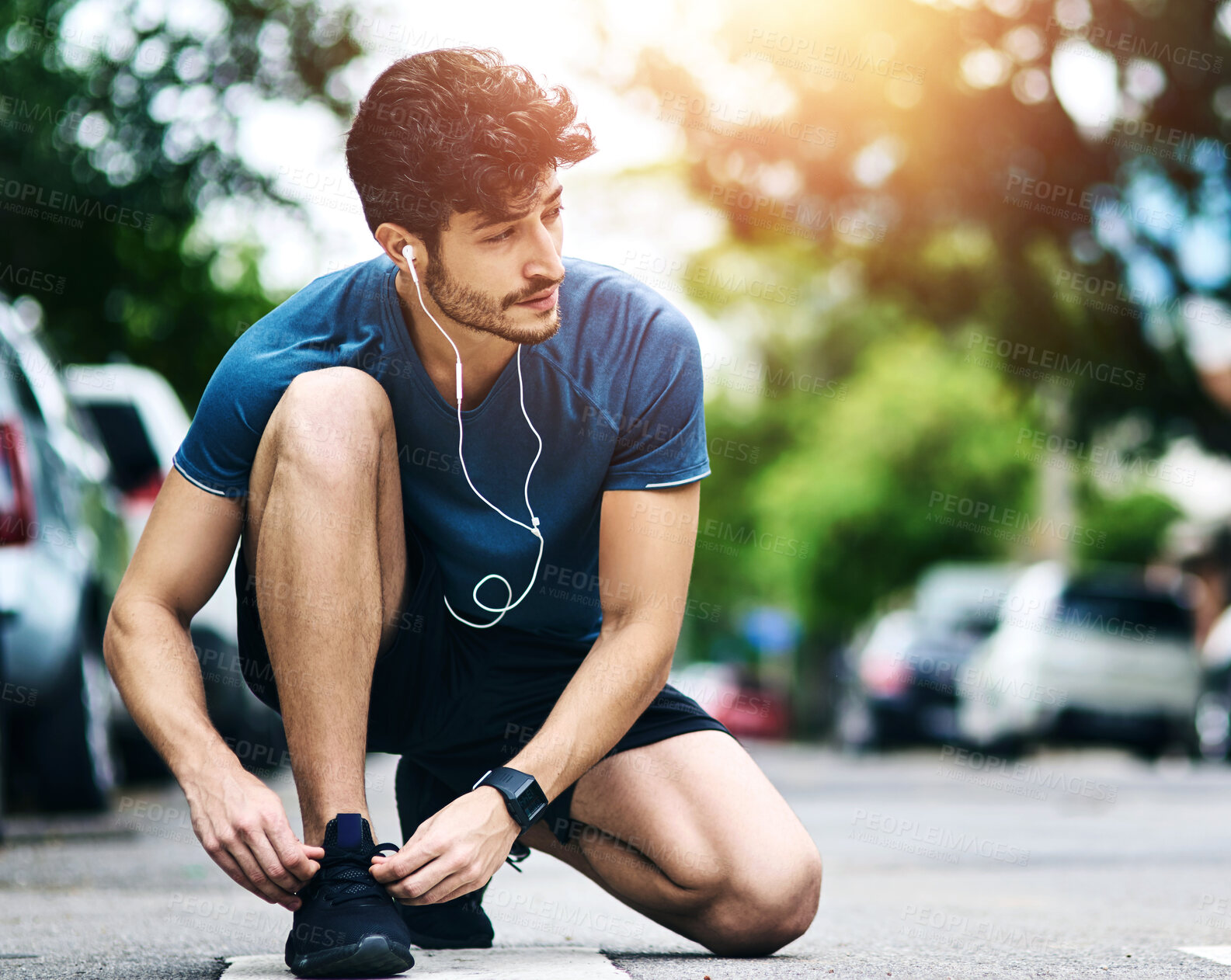 Buy stock photo Exercise, man and tying shoelace in road, fitness and workout or safety preparation with morning routine. Earphones, audio tech and streaming motivation or music, runner and athlete outside in street