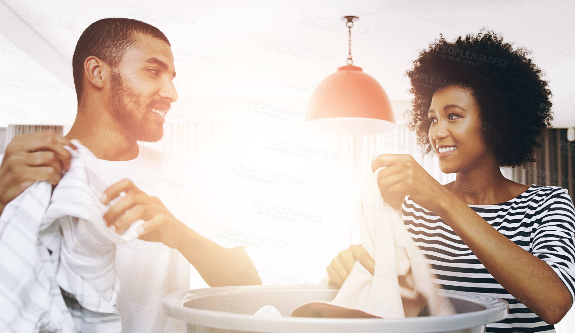 Buy stock photo Happy, couple and sorting clothes in home for laundry day, household work and chores for cleaning with love. Man, woman and together in house to fold washing with bonding, routine and conversation