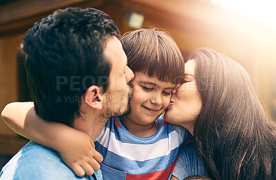 Buy stock photo Happy family, love and parents kiss child outdoor for care, bonding and relax together. Smile, father and mother with kid at backyard to hug for support, connection and healthy relationship by house