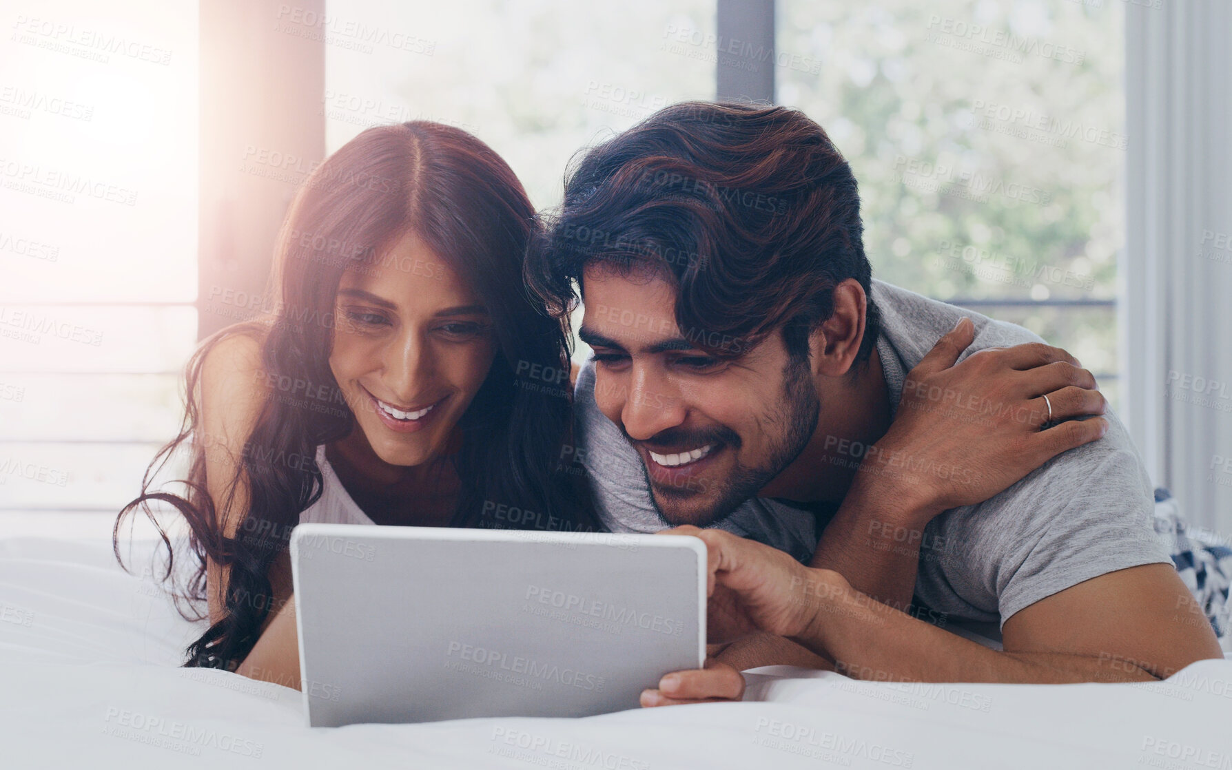 Buy stock photo Happy couple, morning and tablet for streaming film, internet service or online subscription on weekend. Smile, bedroom or people watching on technology for movies, series or valentines day in home