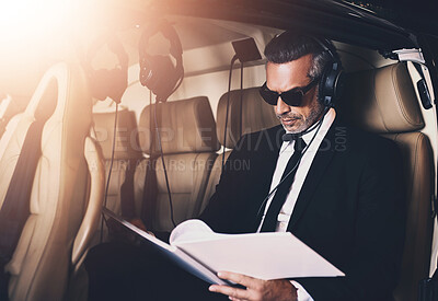 Buy stock photo Man, pilot and business with documents for travel, proposal or international trip for job or career opportunity on flight. Businessman with paperwork or headphones on airplane for private journey