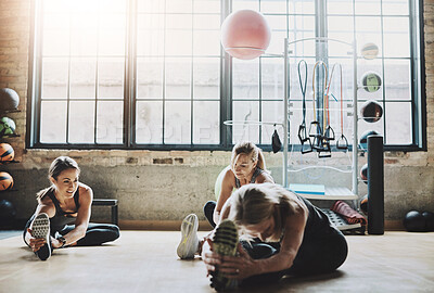 Buy stock photo Women, group and stretching legs in gym, floor and together with coach for training, fitness and health. People, friends and happy with support, teamwork and warm up for exercise, workout or wellness