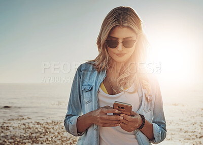 Buy stock photo Woman, beach and texting on smartphone for social media and networking in Miami. Female person, seaside and break or holiday with waiting for date on online dating app and sunset on sunglasses