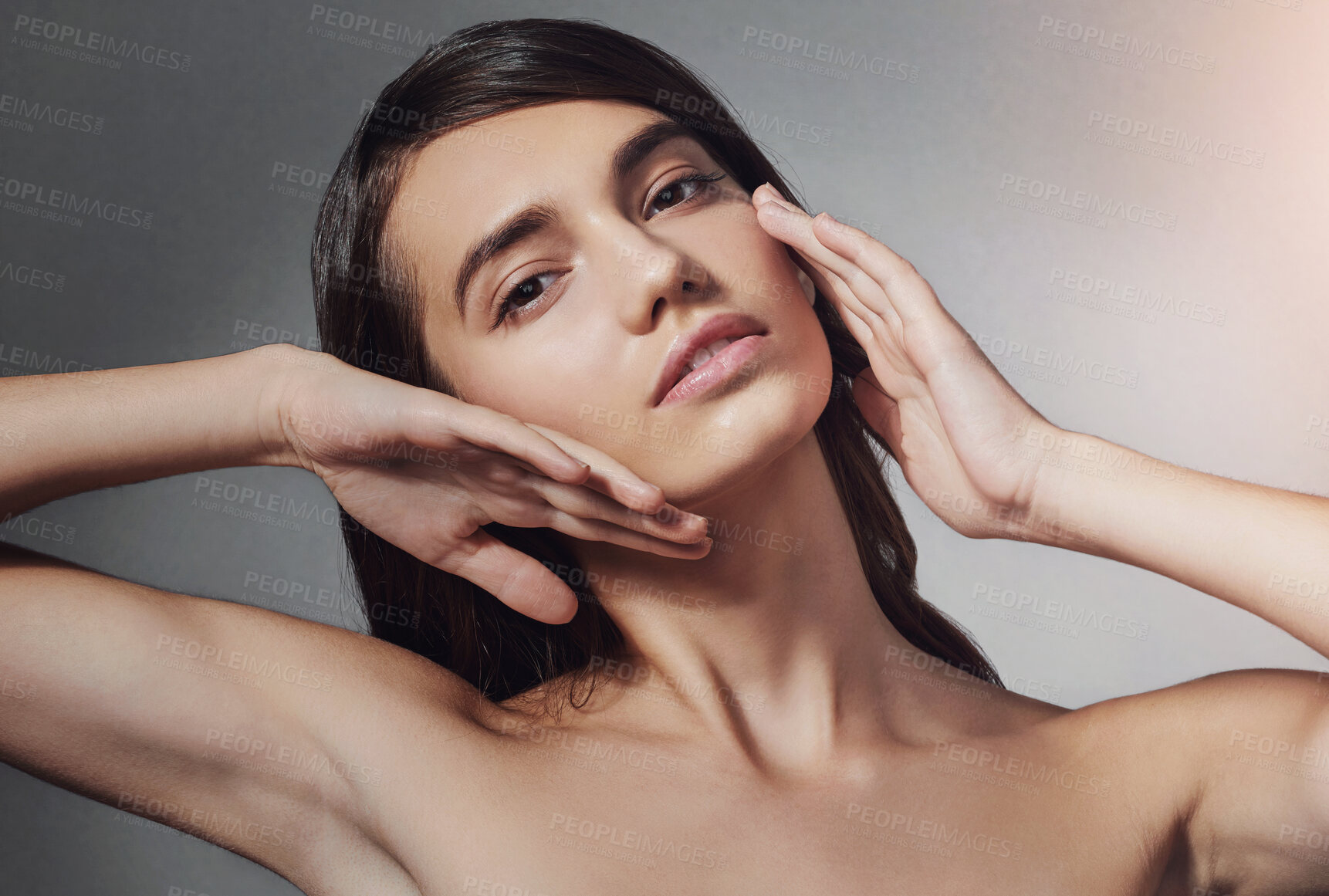 Buy stock photo Portrait, skincare and model touch face for glow, shine and natural isolated on gray studio background. Beauty, makeup and hands of confident woman in cosmetics at spa for dermatology and wellness