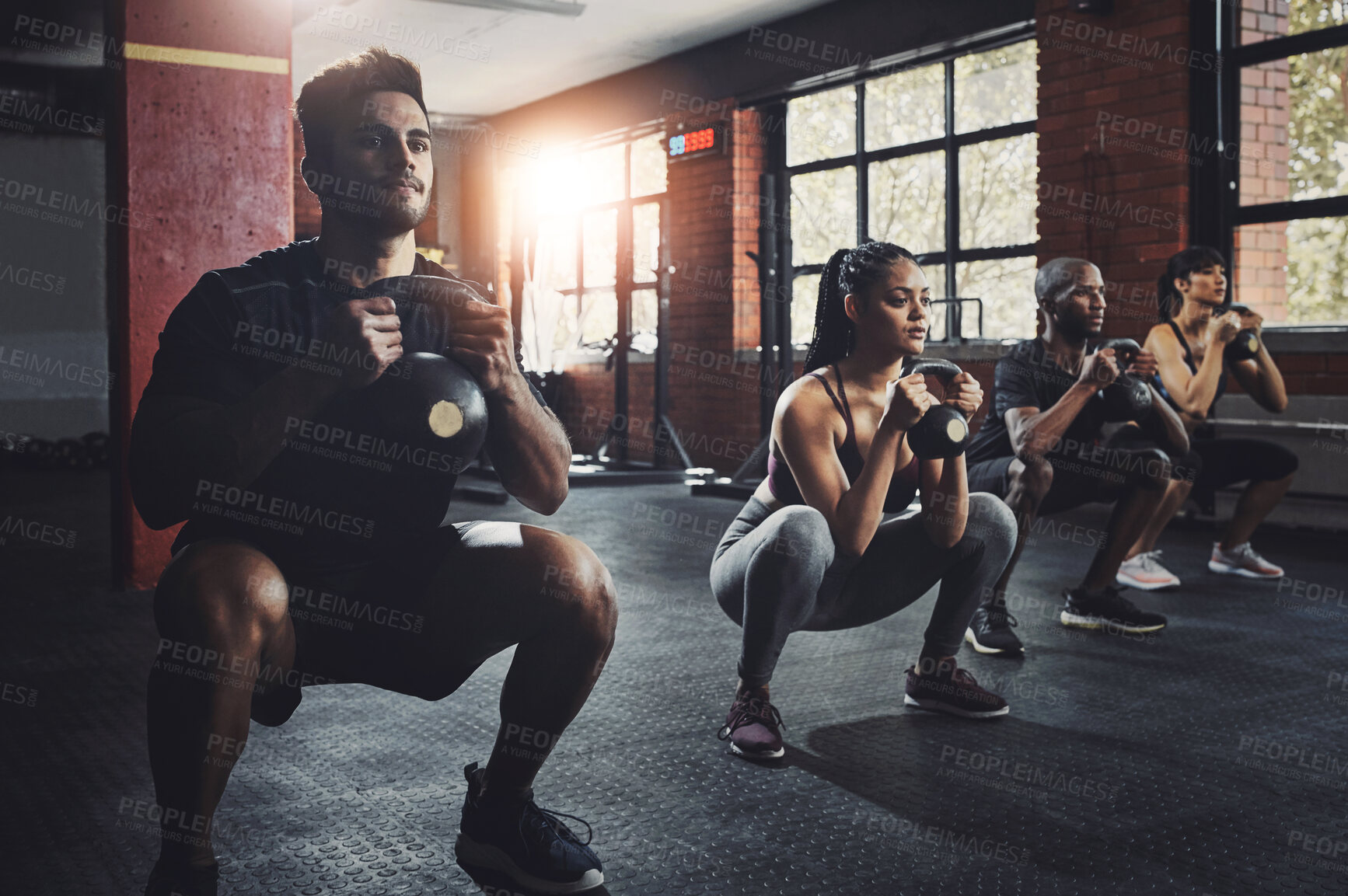 Buy stock photo Group, fitness and workout with kettlebell to squat in class for muscle, wellness or healthy body. Team, exercise and strong people weightlifting for power, bodybuilding and training together at gym