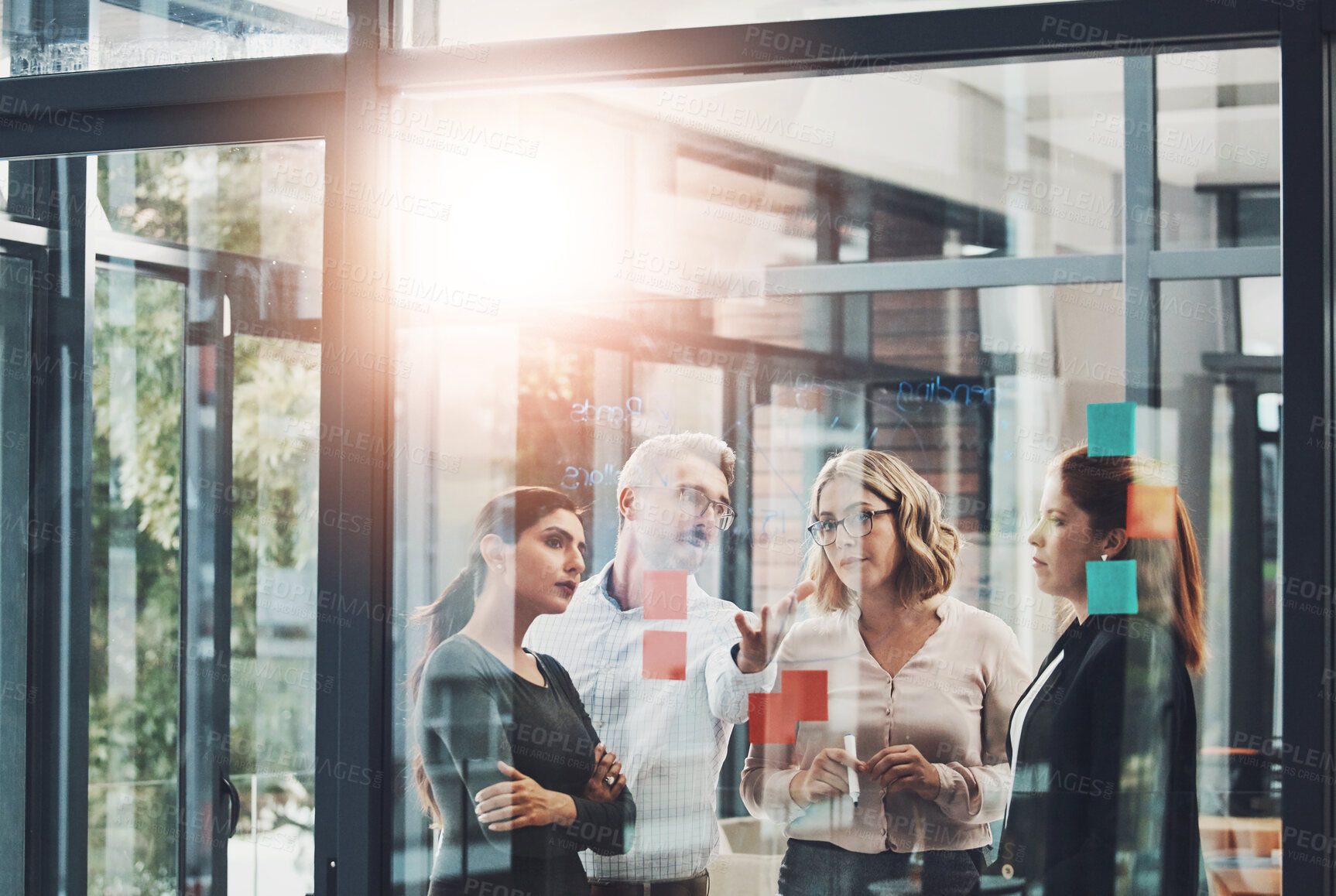 Buy stock photo Woman, team and planning with discussion by glass board with sticky notes, questions and ideas with brainstorming. Coach, training and group by wall, synergy or collaboration with strategy in office