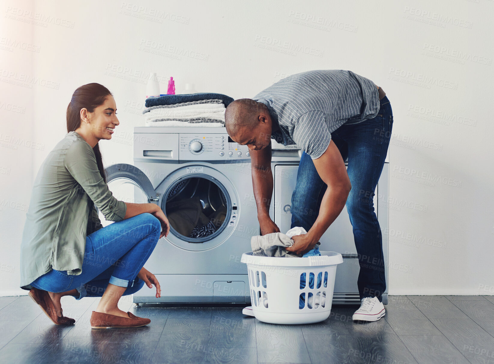 Buy stock photo Smile, couple and help with laundry at washing machine for housekeeping, load clothes or hygiene. Basket, people and happy with housework for chores support, efficiency and domestic teamwork in home