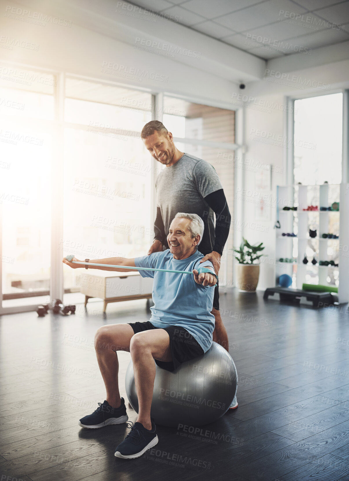 Buy stock photo Stretching, senior man and physiotherapist with band for resistance training, support or muscle workout. Fitness, physiotherapy and happy elderly person with ball for mobility exercise in retirement