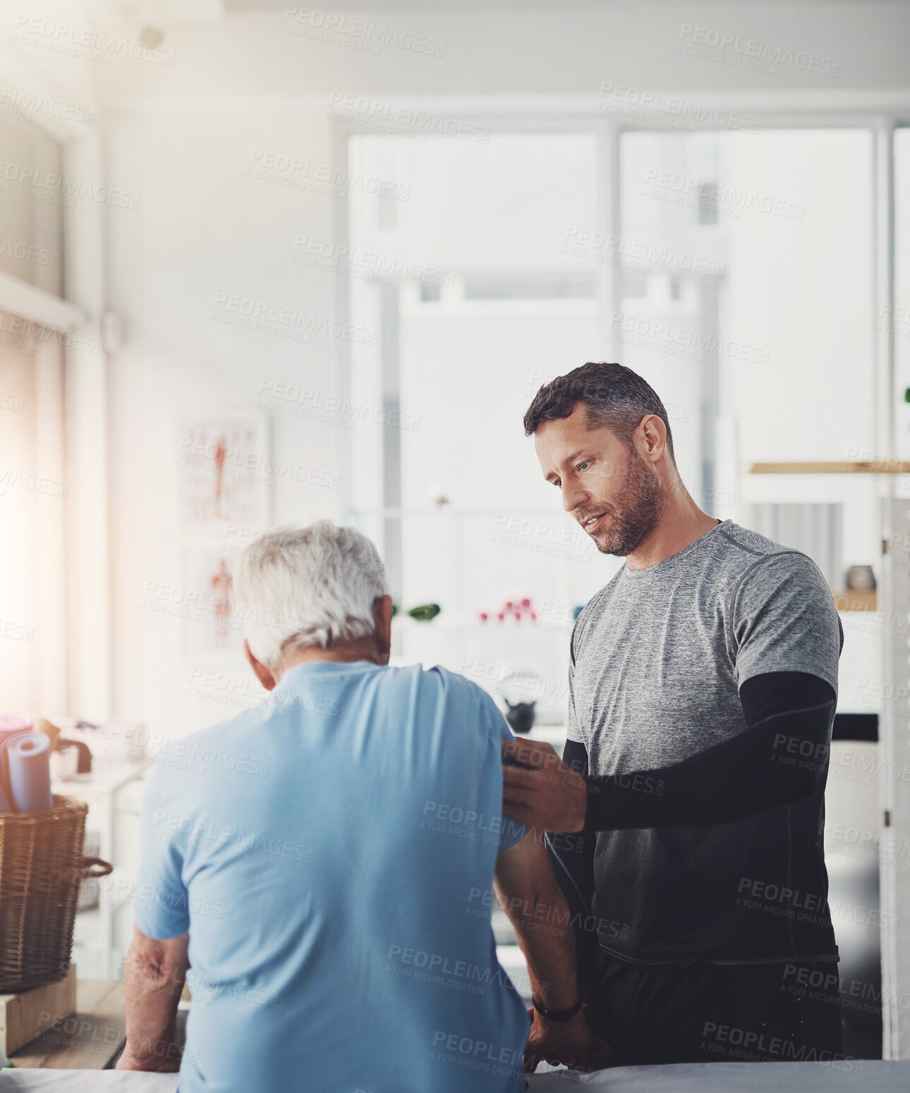 Buy stock photo Physio, arm and senior man with rehabilitation, conversation and healthcare check in clinic. Consultation, client and elderly care with physical therapy, wellness and injury support with chiropractor