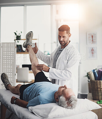 Buy stock photo Massage, physiotherapist and senior man on bed for knee stretching, assessment or healthcare in retirement. Clinic, physiotherapy and elderly person on table for muscle healing, fitness or joint pain