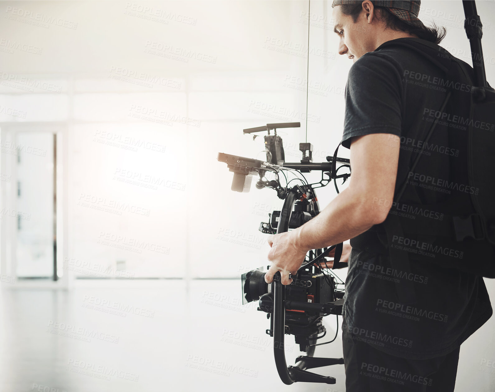 Buy stock photo Photographer, camera and filming with stabilizing equipment on set for photography, media and magazine. Cameraman, focus and person backstage for shooting, production and film as director with lens