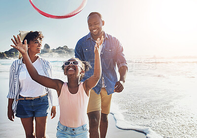 Buy stock photo Happy, hoop and family by beach on vacation, adventure or holiday for bonding in summer. Fun, smile and African girl child with parents playing with plastic ring toy by ocean on weekend trip.