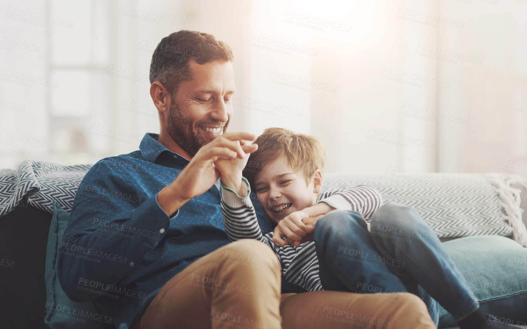 Buy stock photo Father, boy and laughing on sofa together in home, bonding and hug for funny conversation. Daddy, son and happy family playing in living room for joke, talk and embrace for security in relationship