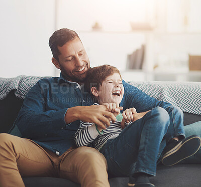 Buy stock photo Tickle, laughing and dad with child on sofa for bonding, happy relationship and relax in living room. Family, lovel and father and young boy having fun for joke, playing and cuddle on couch in home
