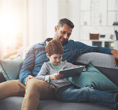 Buy stock photo Tablet, relax and father with child on sofa playing online video game in living room at home. Happy, bonding and dad teaching boy kid esports on digital technology for fun together in lounge at house