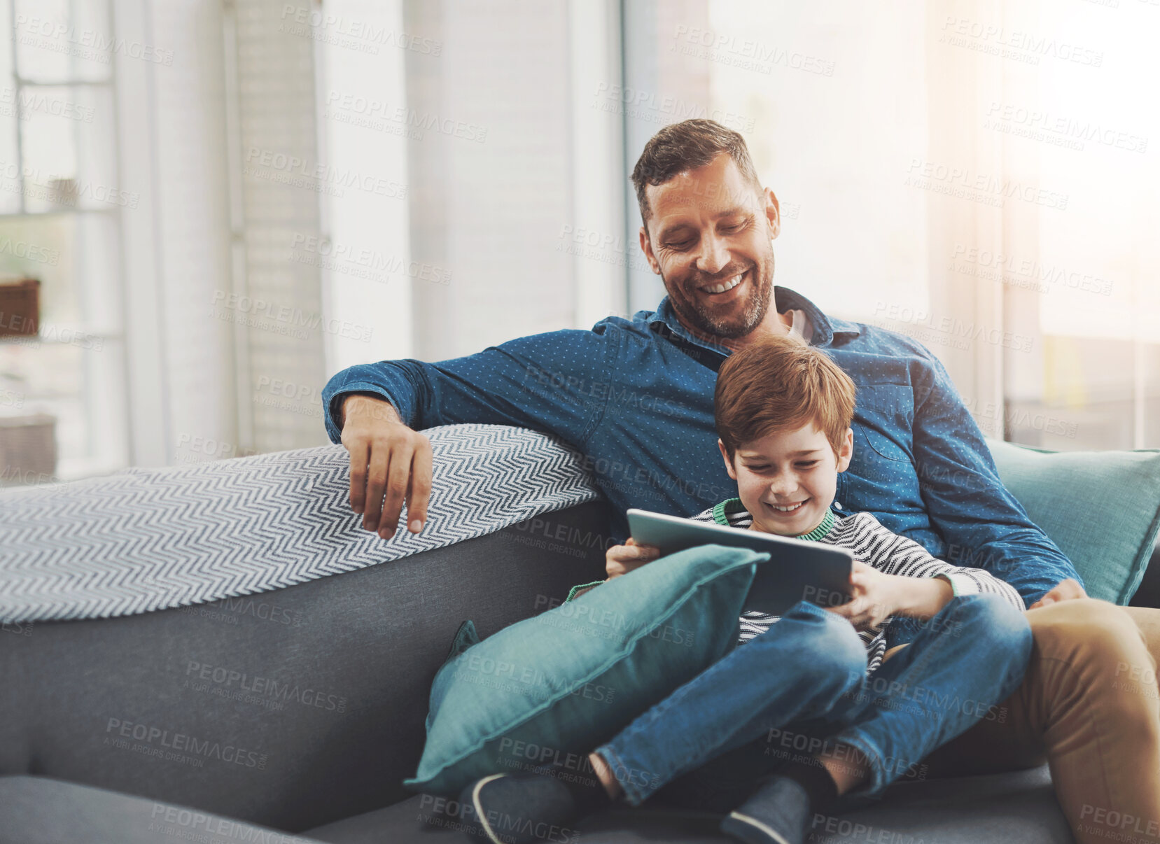 Buy stock photo Happy, tablet and dad with child on sofa for online streaming, playing games and internet. Family, home and father with young boy on digital tech for watching movies, cartoons and videos for bonding