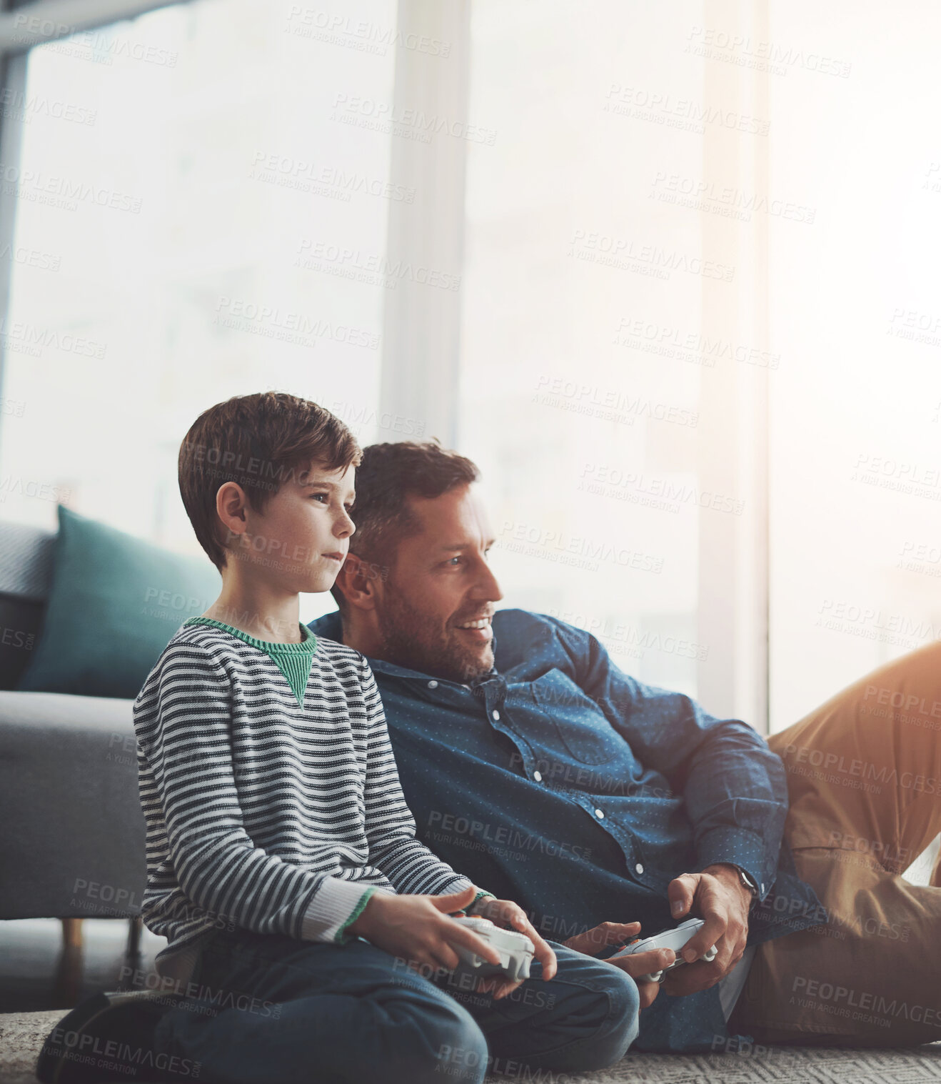 Buy stock photo Father, relax and playing games with child on console for entertainment or bonding on floor at home. Dad, son or kid with smile and enjoying esports or fun together on carpet with controller at house
