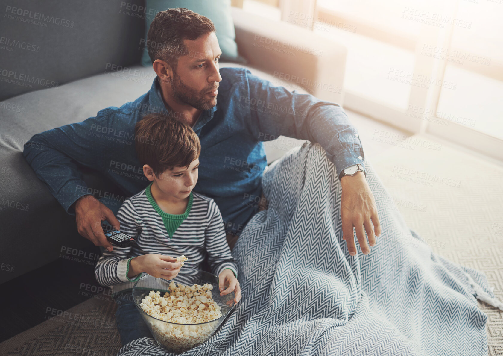 Buy stock photo Popcorn, relax and father watching tv with child on floor in living room at family home. Blanket, bonding and dad with kid for streaming movie, film or show with snack in lounge at house in Canada.
