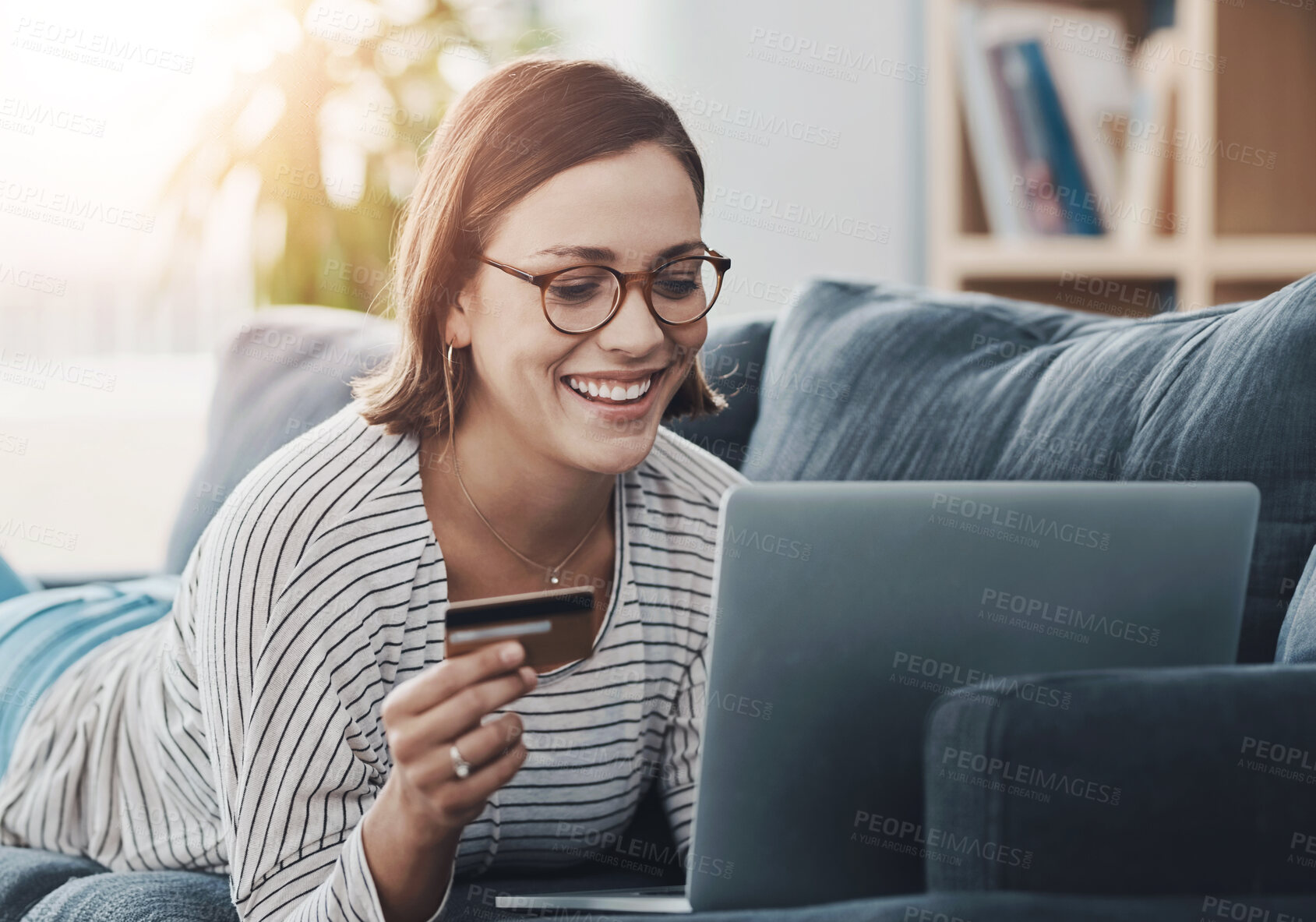 Buy stock photo Happy, home and woman on laptop with credit card for online shopping, discount and sale. Doomspending, ecommerce and girl typing on fintech app or banking with rewards, voucher code and savings bonus