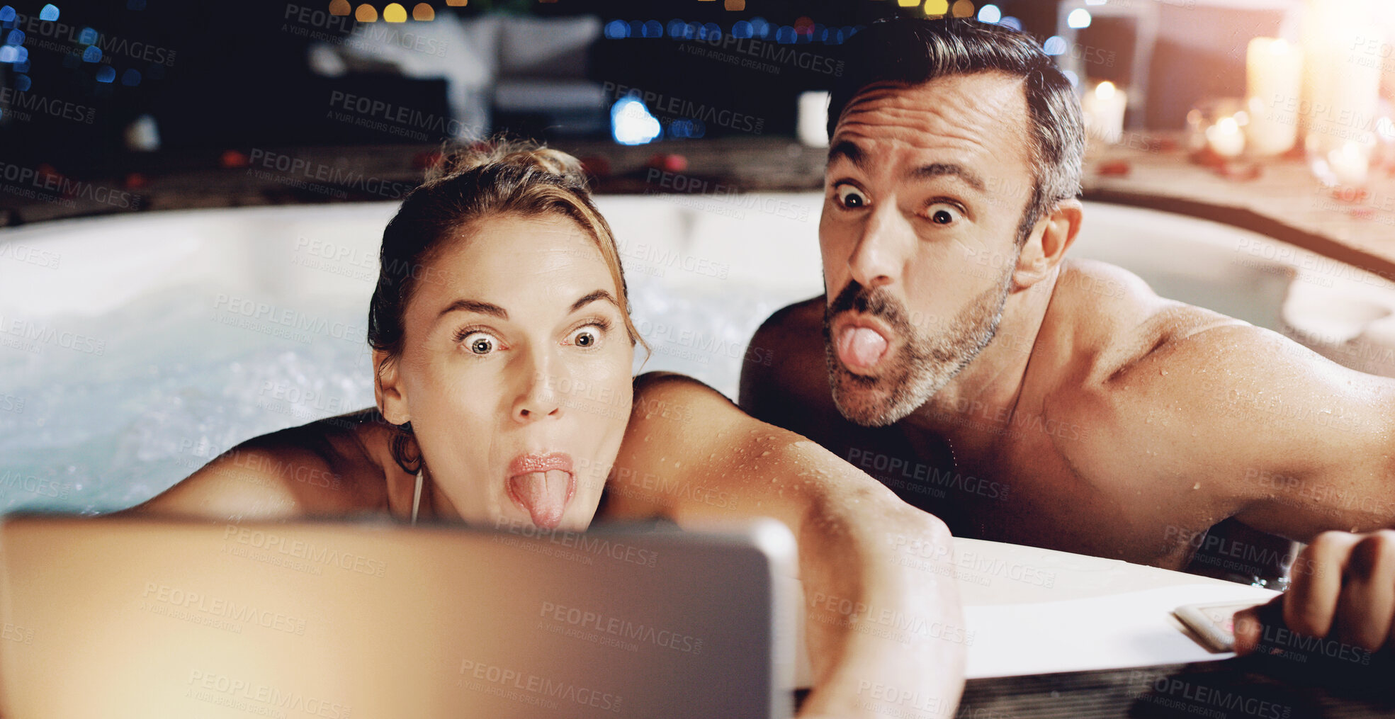 Buy stock photo Tablet, funny face and selfie of couple in hot tub with tongue out for social media or romantic date. Technology, man and woman take picture in water to relax for vacation, holiday and memory at spa