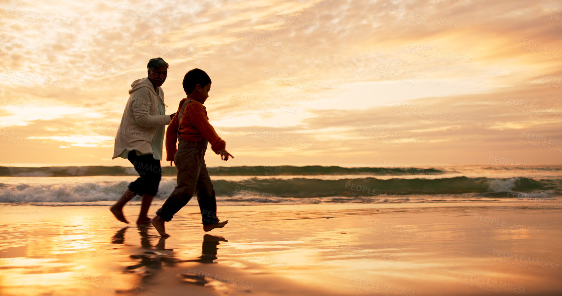 Buy stock photo Mama, son and walking on beach at sunset for family bonding, travel for wellness with playful fun. Mother, boy child and together by ocean with sand on vacation, adventure or freedom in Indonesia