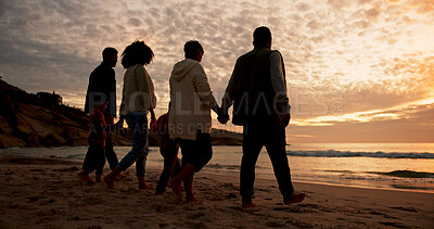 Buy stock photo Family, sunset and holding hands at beach in summer for relax, travel and vacation as silhouette. Parents, children and back at ocean with solidarity for holiday, trust and love together by walking
