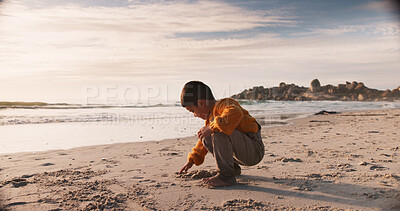 Buy stock photo Boy, child and drawing on sand at beach, travel and explore nature or ocean on vacation. Male person, kid and sea for wellness or play in Florida on weekend, water and relax on holiday adventure