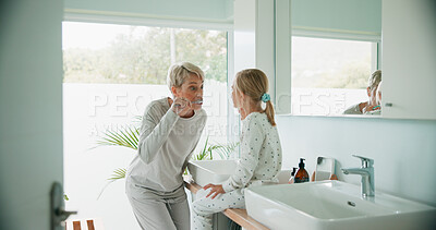 Buy stock photo Grandmother, kid and brushing teeth in bathroom for care, dental health and learning oral hygiene. Child, grandma and girl with toothbrush for cleaning, wellness and morning routine in family home