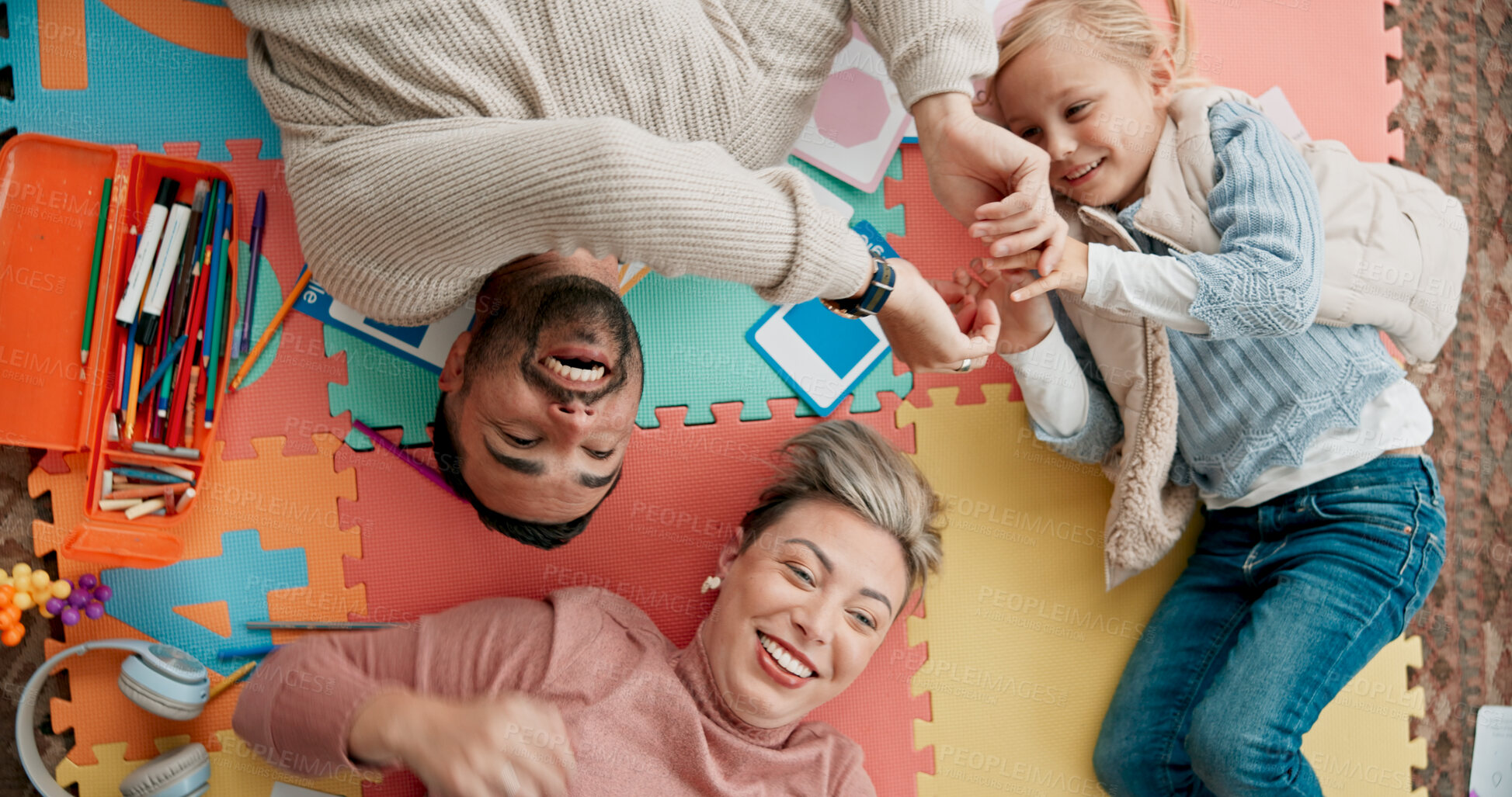 Buy stock photo Above, family and happy on floor with games for fun, entertainment and bonding. People, parents and girl or kid with smile in playing puzzle at home for child or brain development and growth