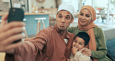 Buy stock photo Selfie, happy and muslim family on sofa in home for Eid celebration with faith in living room. Goofy, love and islam parents with boy child for photography picture on ramadan with hijab and kofia.